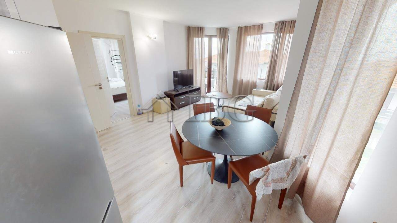 Bright living room with dining area and large windows in Kosharitsa apartment.