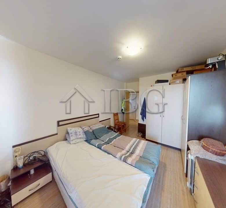Bedroom with bed, wardrobe, and desk in Kosharitsa apartment.