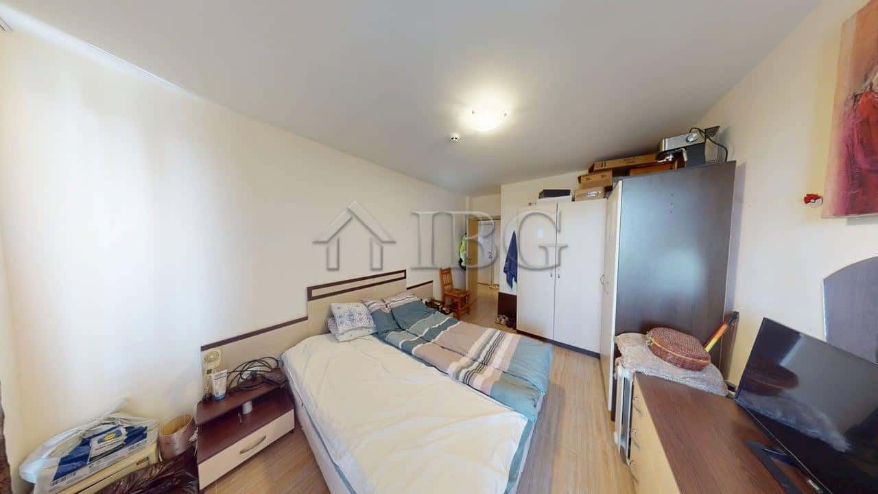 Bedroom with bed, wardrobe, and desk in Kosharitsa apartment.