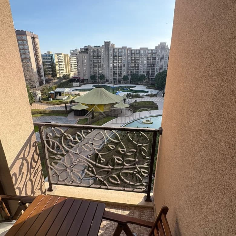 Balcony view of pool and city skyline from a studio apartment.