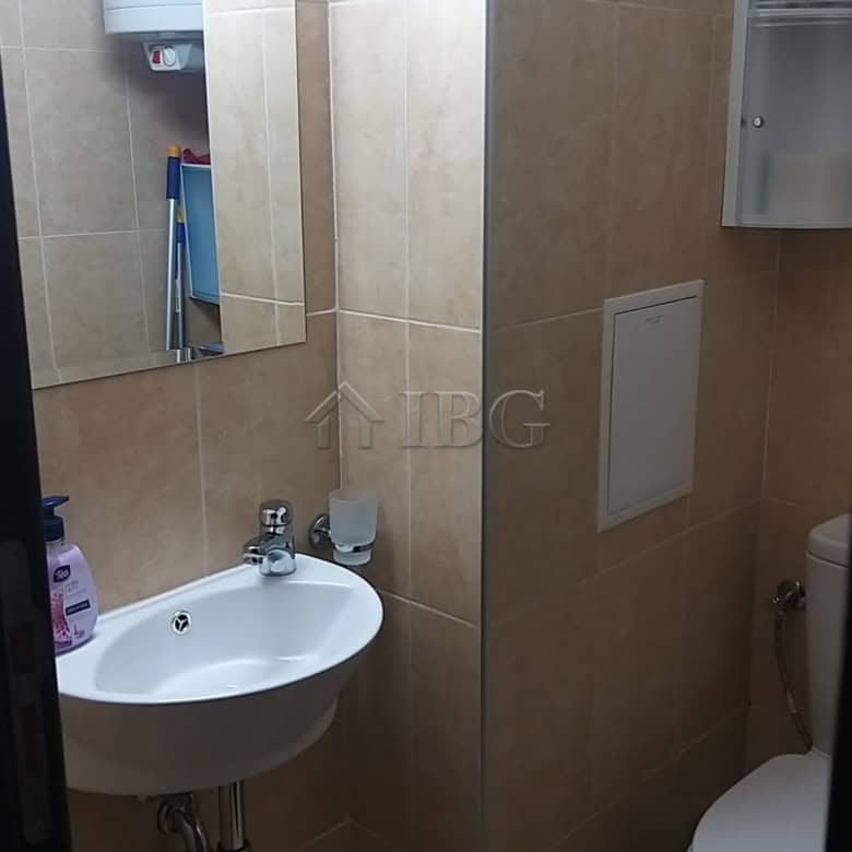 Small bathroom with sink, mirror, and toilet in Sveti Vlas apartment.