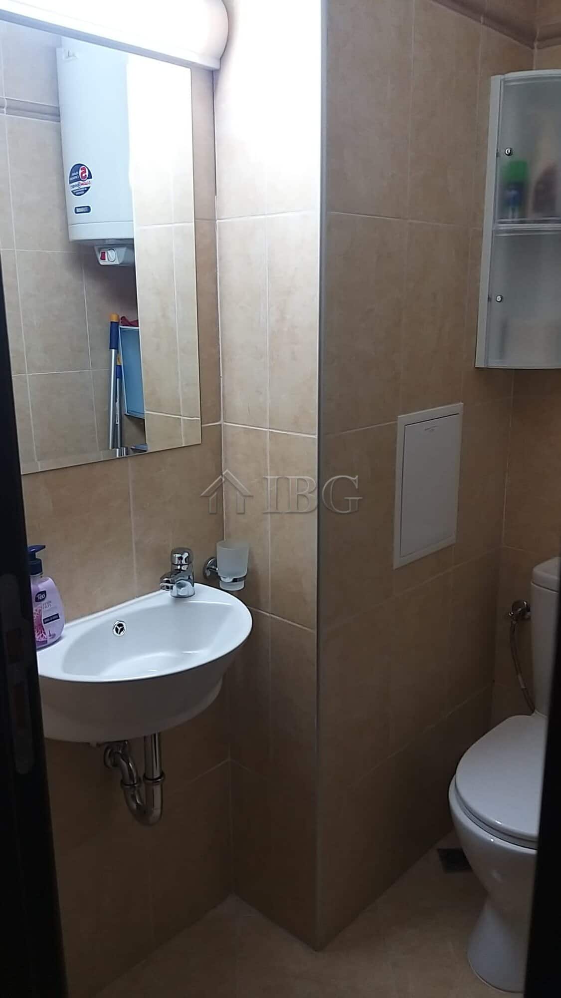 Small bathroom with sink, mirror, and toilet in Sveti Vlas apartment.