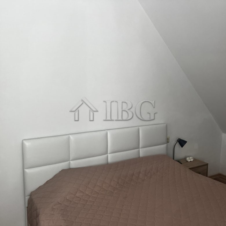 Modern bedroom with white headboard and sea view in Ravda apartment.