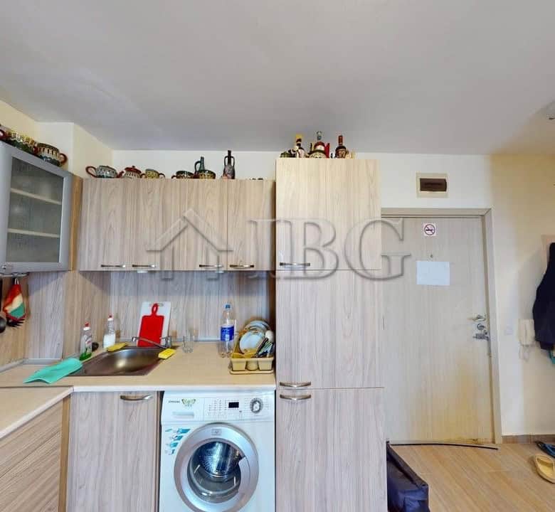 Modern kitchen in Kosharitsa apartment with washing machine and storage.
