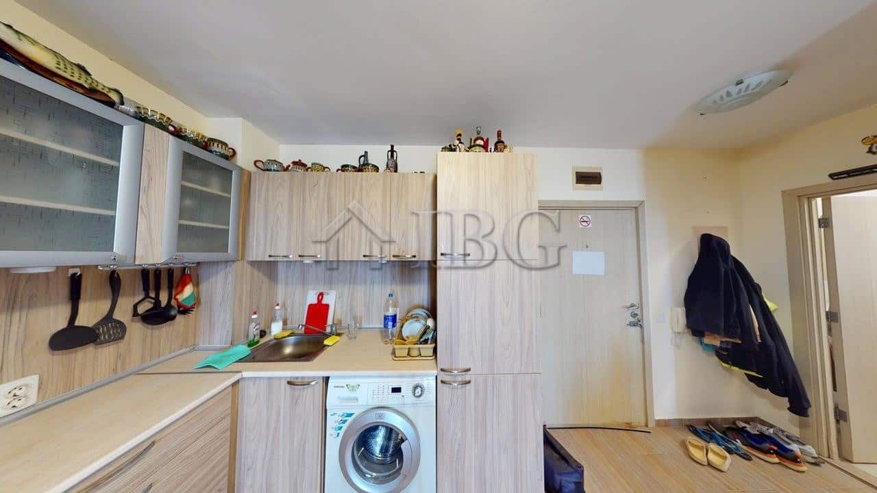 Modern kitchen in Kosharitsa apartment with washing machine and storage.