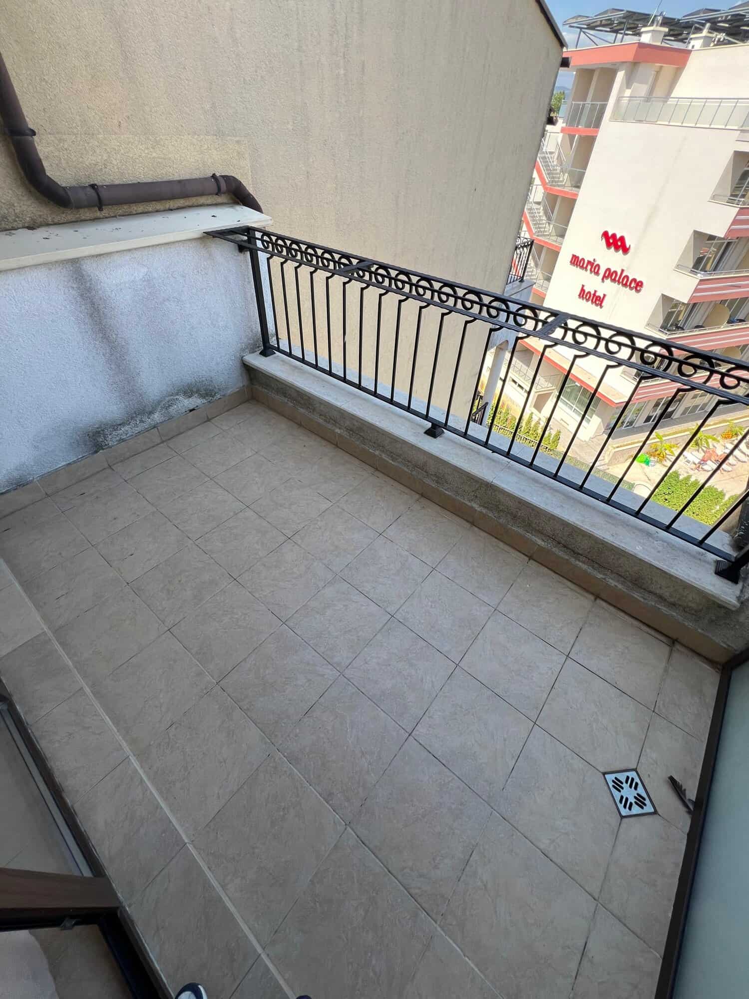 Balcony overlooking Sunny Beach cityscape with railing and tiled floor, perfect for relaxing and enj.
