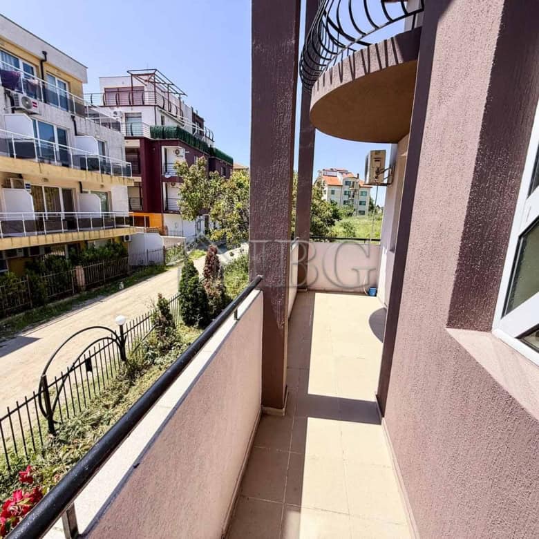 Bright south-facing balcony with views of neighboring buildings.