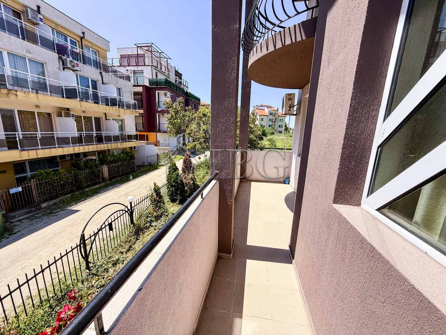 Bright south-facing balcony with views of neighboring buildings.