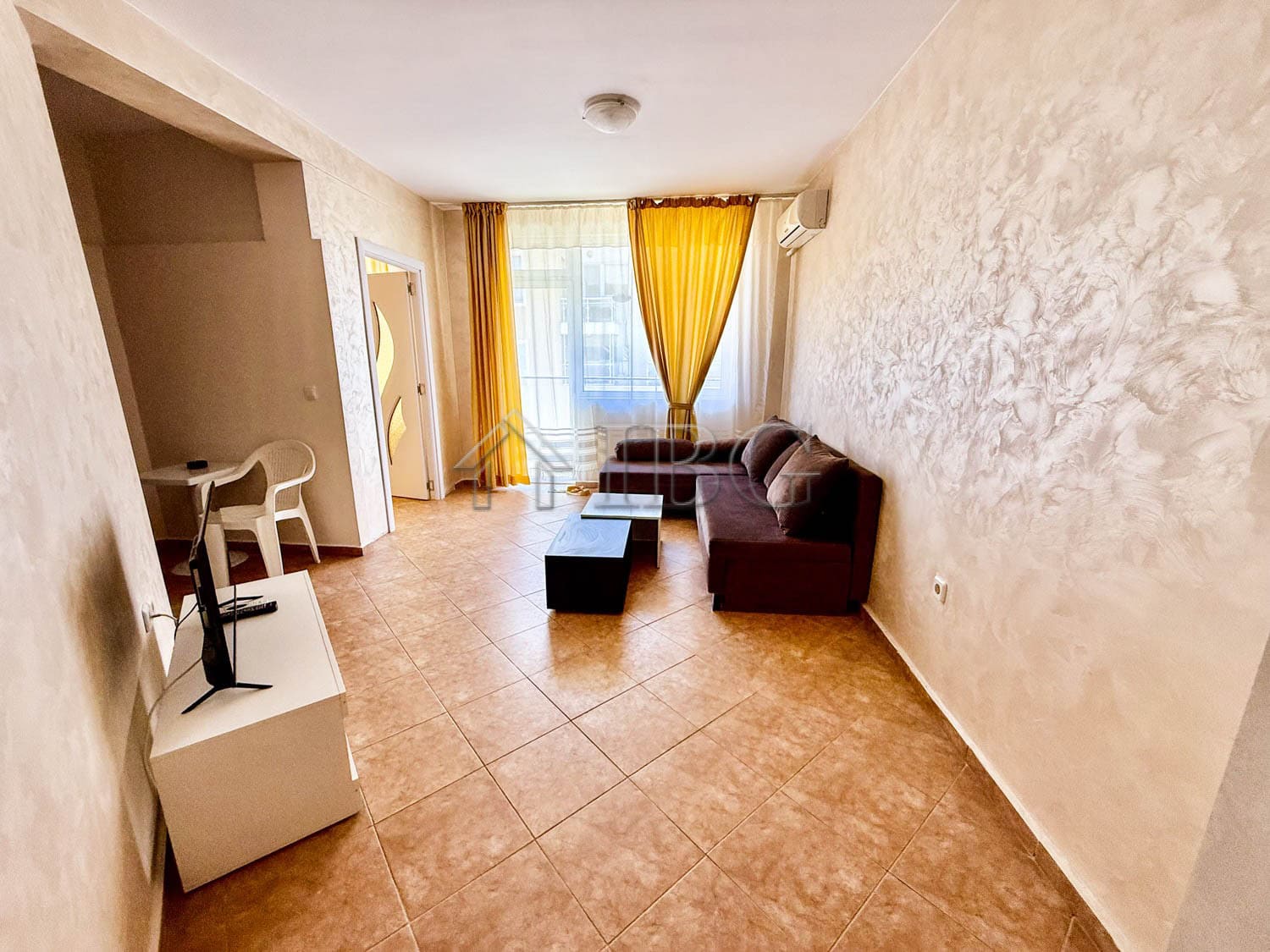 Bright living room with south-facing windows and yellow curtains.