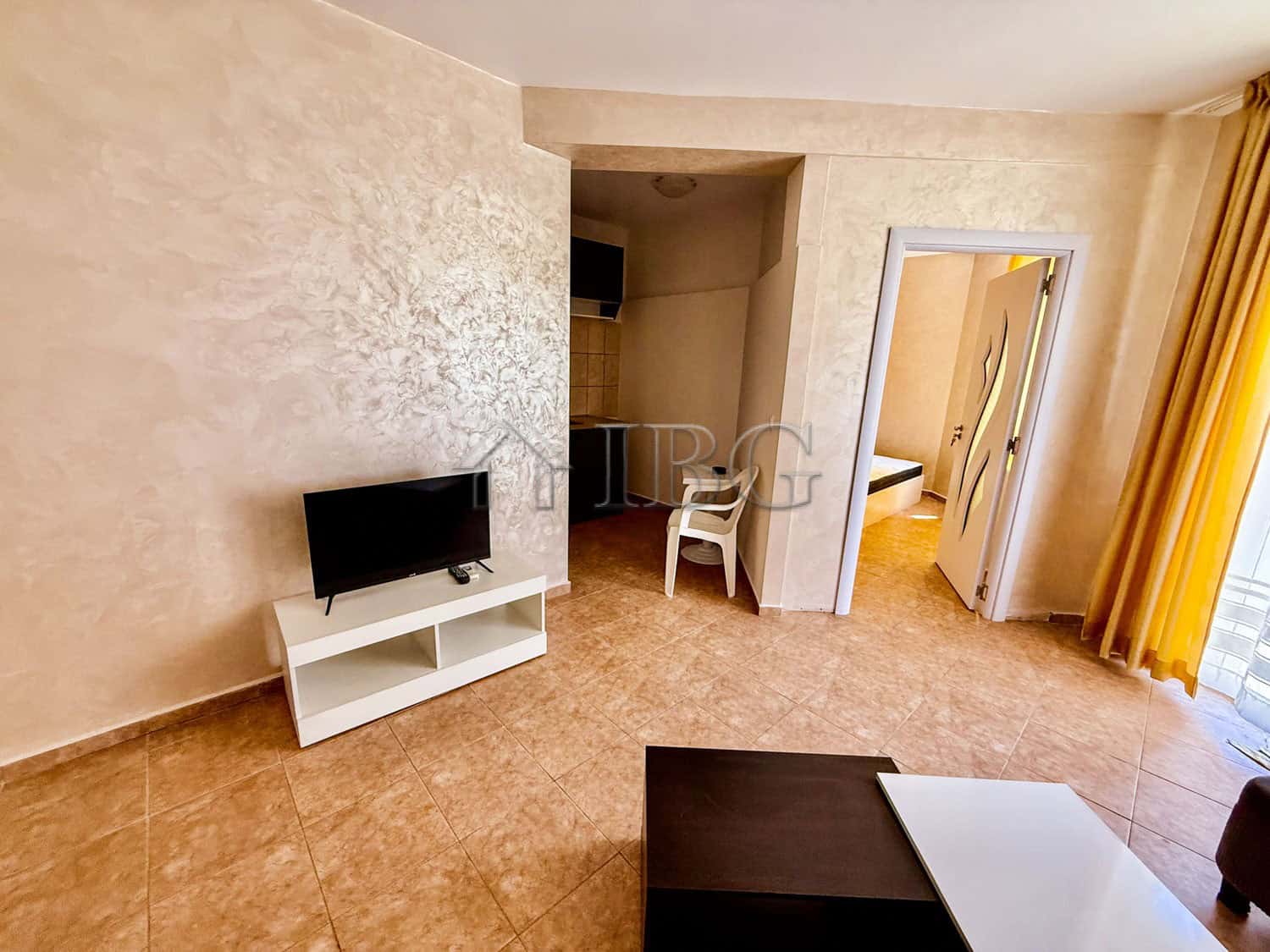 Bright south-facing apartment with living area and TV.