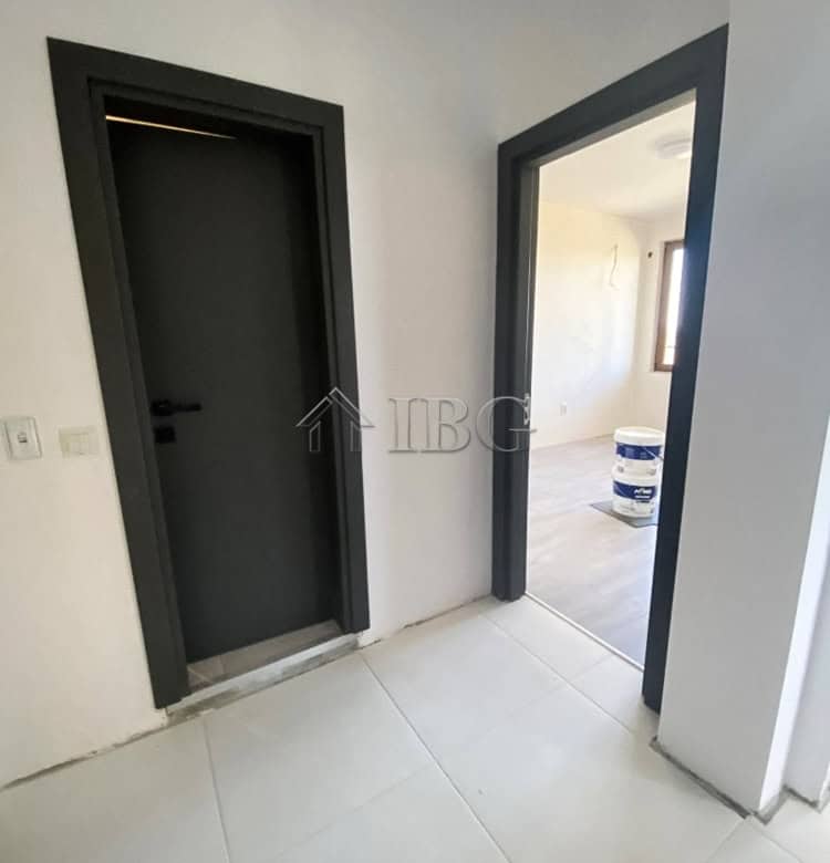 Modern apartment entrance with black door and white walls, close to Balchik.