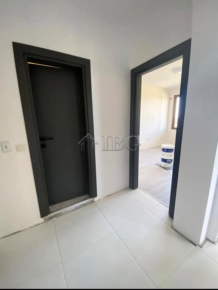 Modern apartment entrance with black door and white walls, close to Balchik.