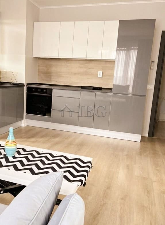Fully furnished 1-bedroom apartment kitchen with modern cabinets and appliances.