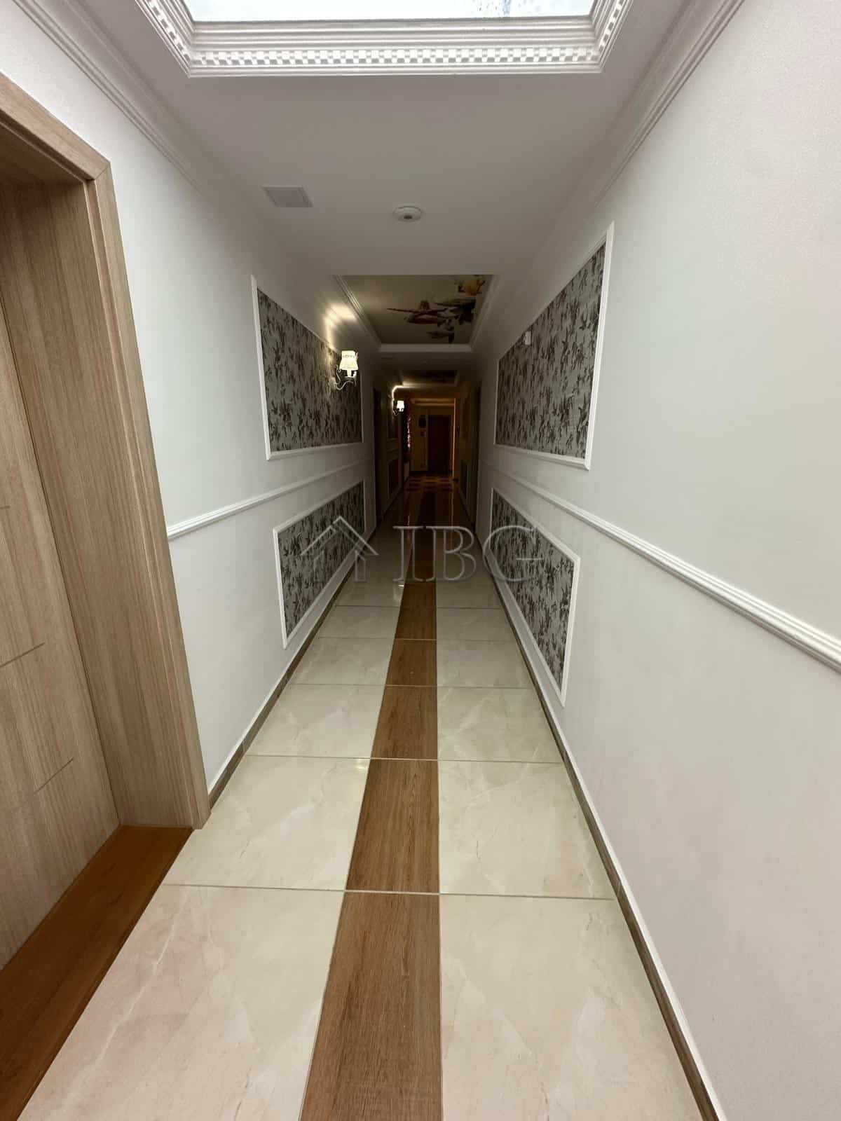Bright, clean corridor with elegant wall decor and wooden accents.