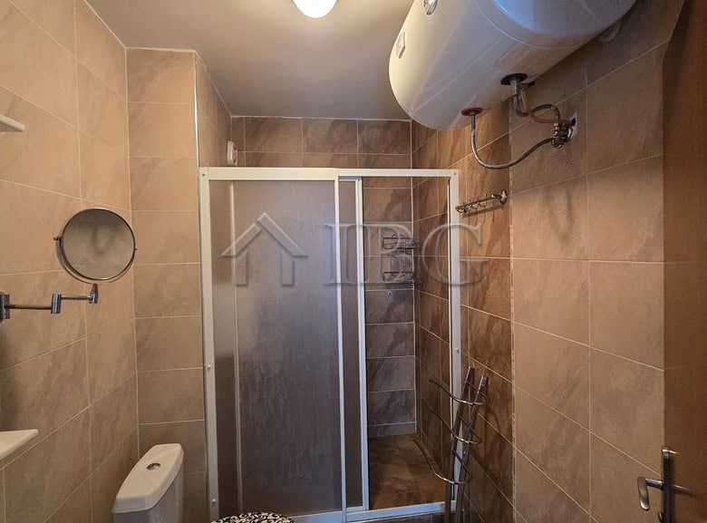 Bathroom with shower enclosure and water heater in Sunny Beach.