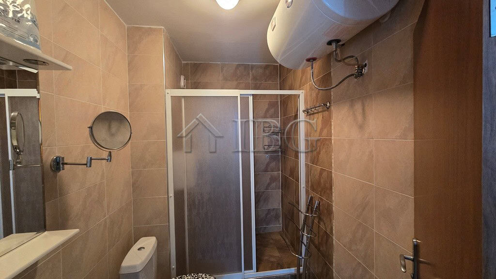 Bathroom with shower enclosure and water heater in Sunny Beach.
