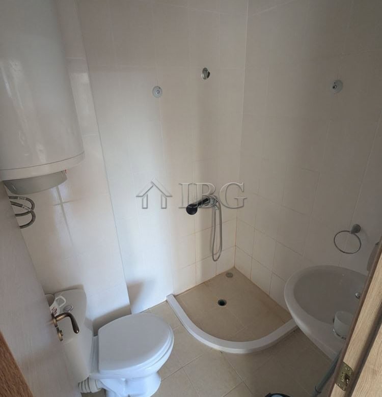 Compact studio bathroom with shower, toilet, and sink in Sunny Beach.