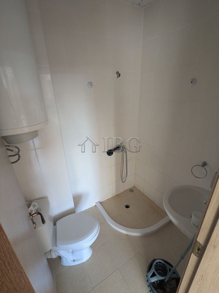 Compact studio bathroom with shower, toilet, and sink in Sunny Beach.