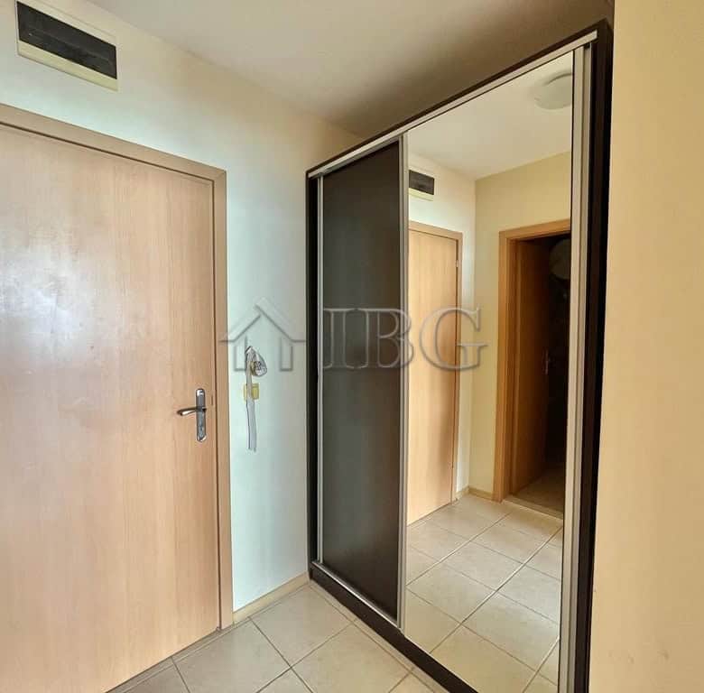 Modern beachfront home interior with wooden door and mirrored closet door.