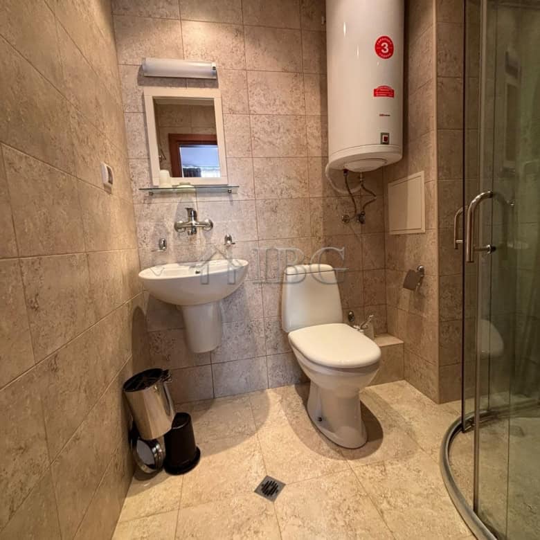 Modern bathroom with shower, toilet, and water heater in Dawn Park, Sunny Beach.