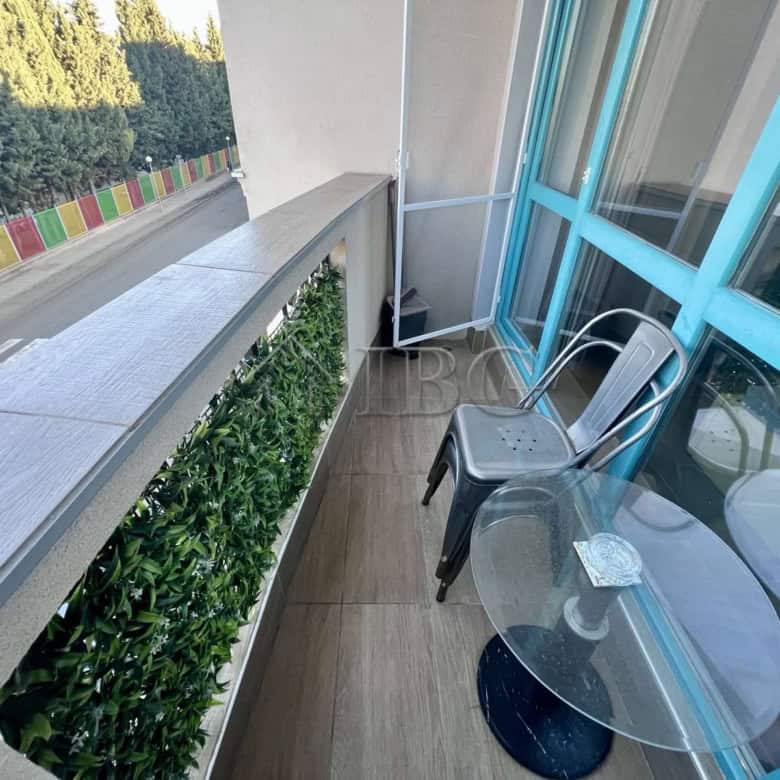 Balcony of a furnished studio apartment at Magnolia Residence 5 in Sunny Beach, featuring a small gl.