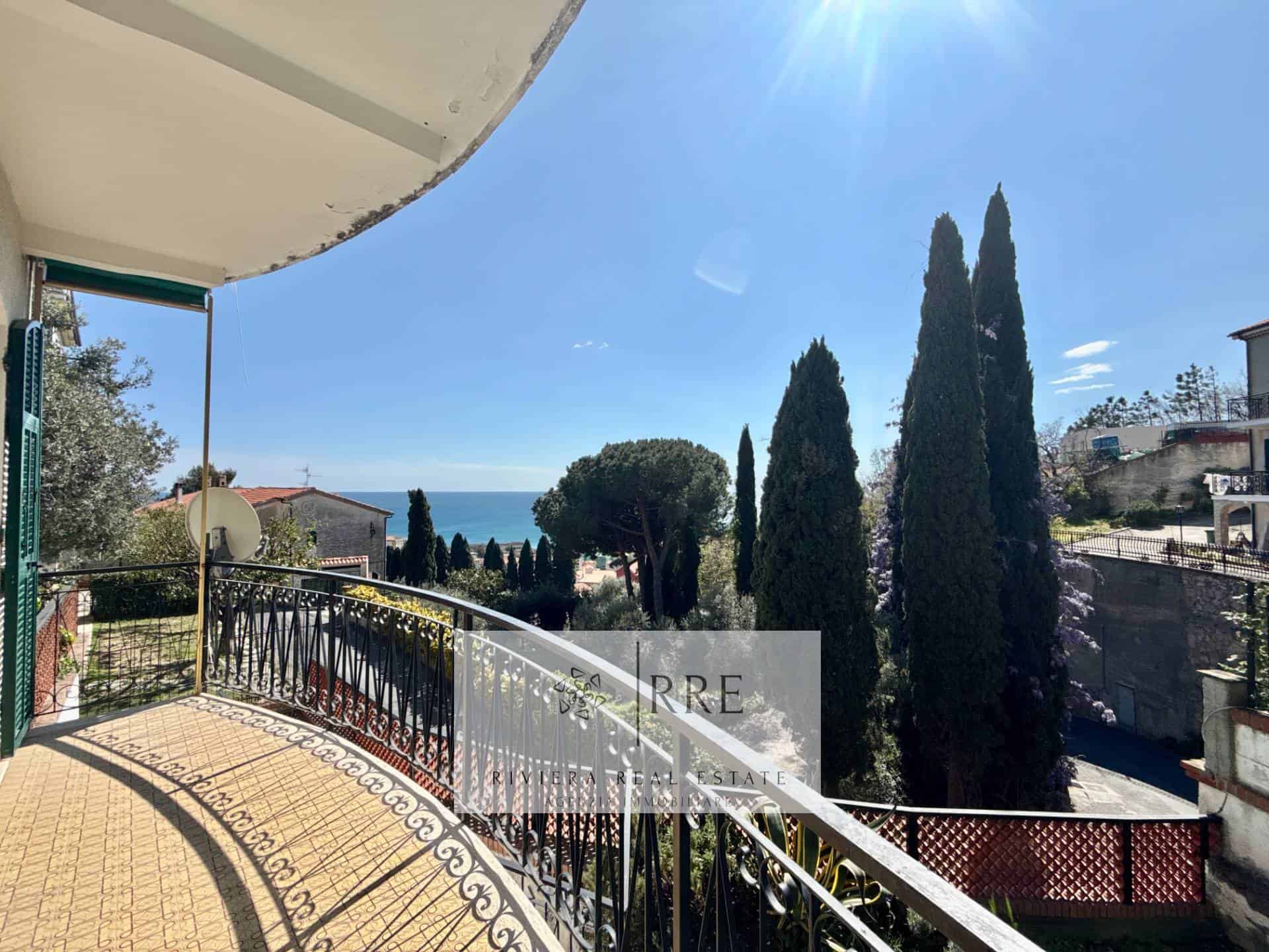 Sea view balcony with cypress trees and ocean in the background.