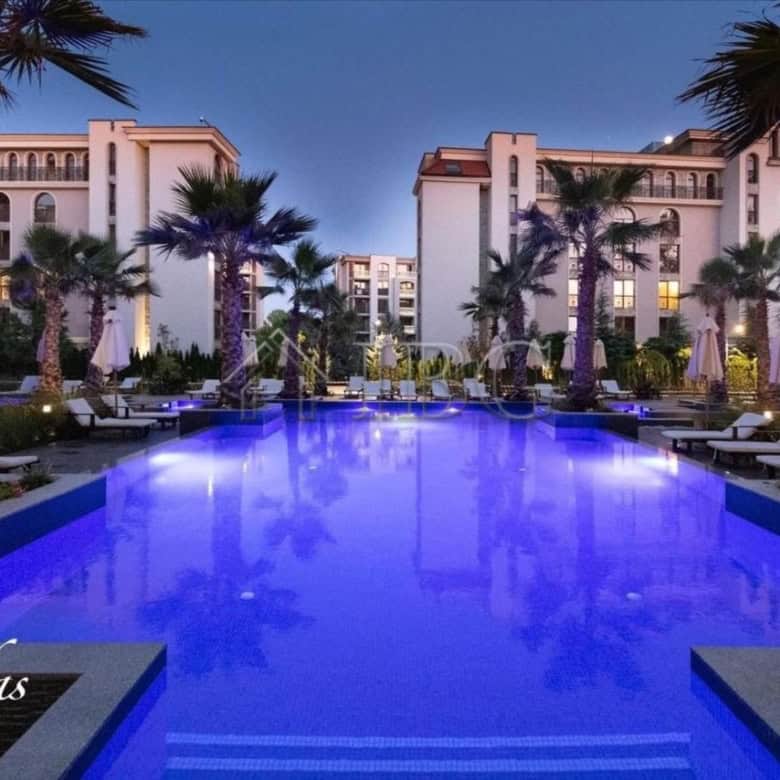 Pool view with palm trees and resort buildings in Sunny Beach, Bulgaria.