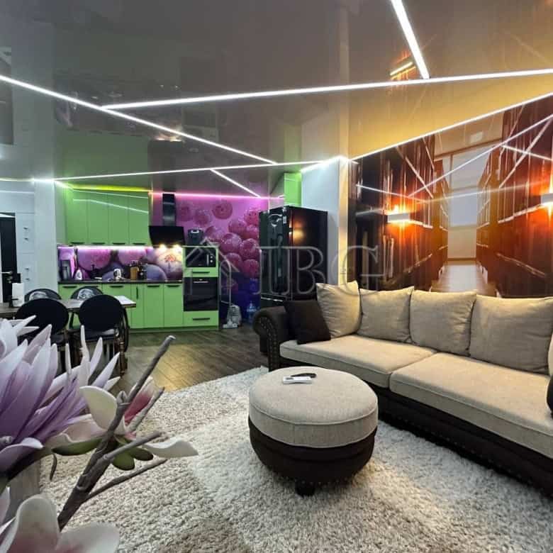 Stylish living room featuring contemporary furniture, colorful lighting, and a cozy atmosphere for r.