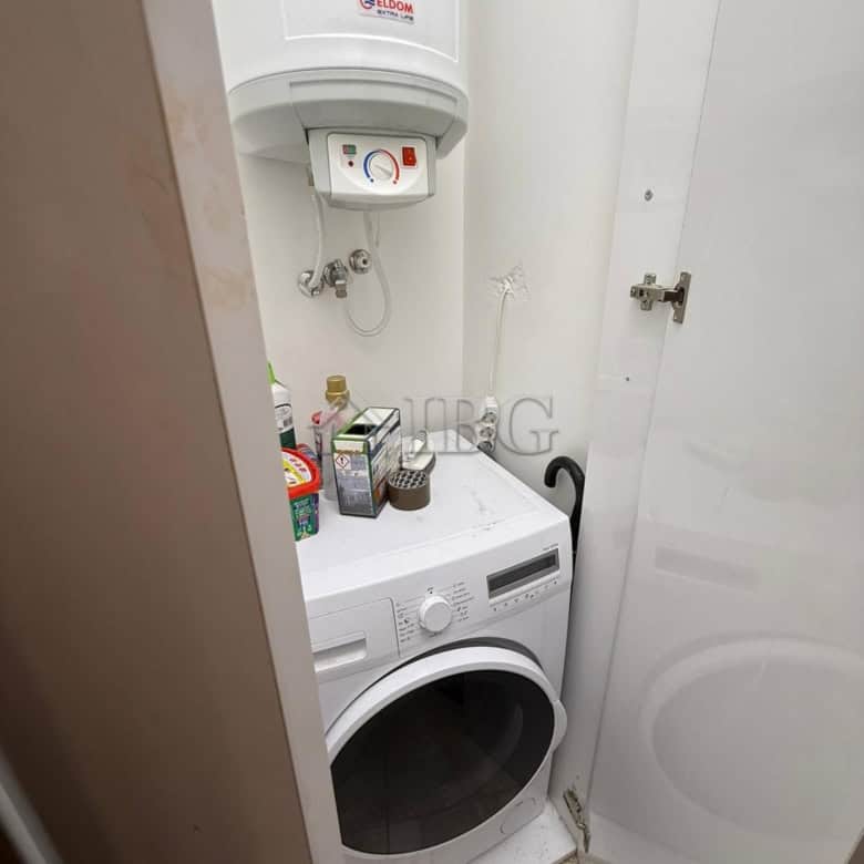 Modern laundry area with washing machine and water heater in Porto Paradiso complex.