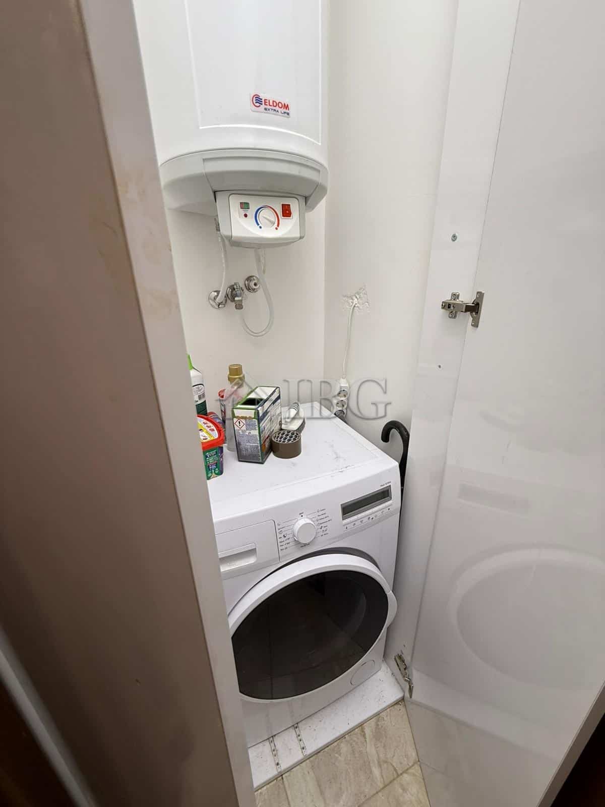 Modern laundry area with washing machine and water heater in Porto Paradiso complex.