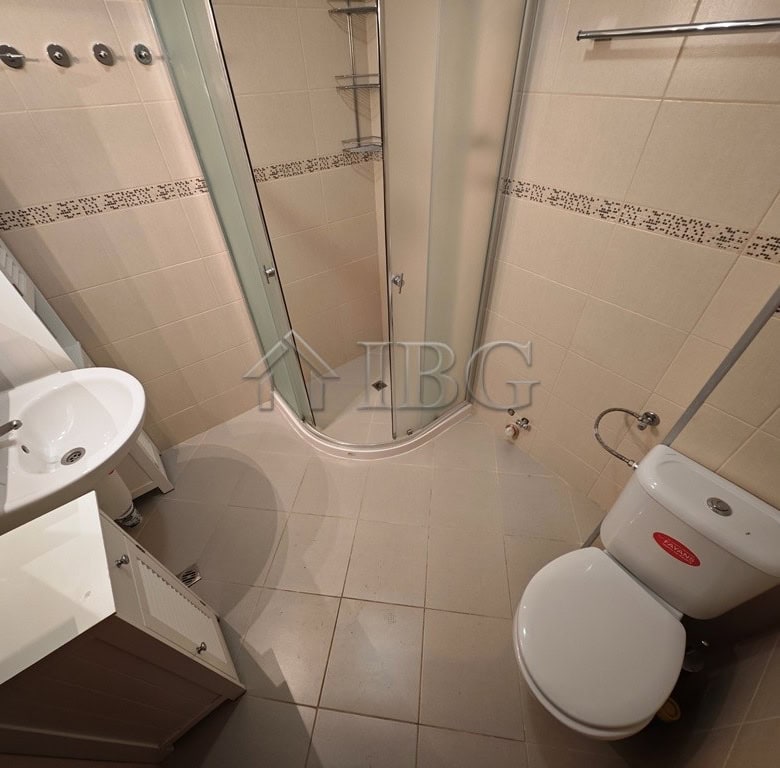 Bathroom with shower cabin, sink, and toilet in a one-bedroom apartment at Parus Complex, Pomorie.