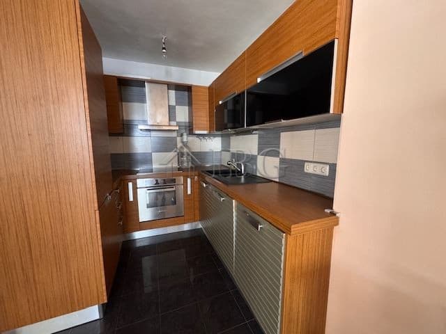 Modern kitchen with wooden cabinets and black appliances in Vazrazhdane, Burgas.