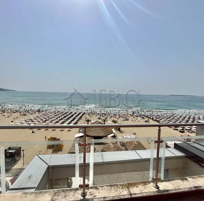 Beautiful beachfront property overlooking sunny sandy beach and ocean waves. Perfect summer retreat.