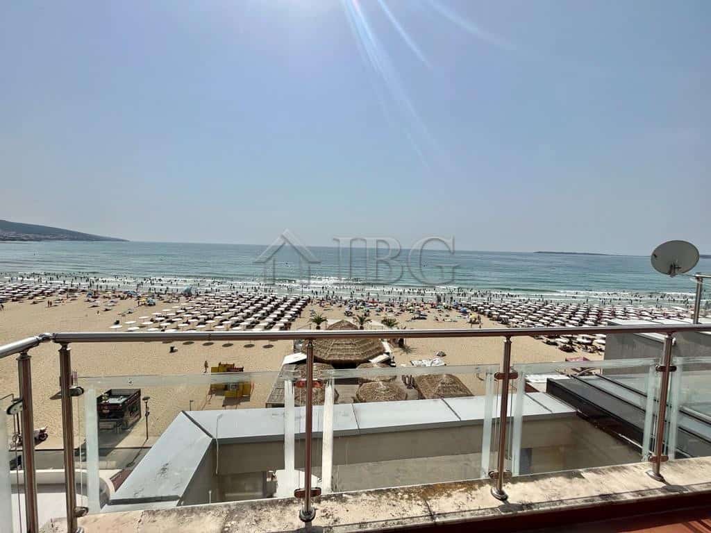 Beautiful beachfront property overlooking sunny sandy beach and ocean waves. Perfect summer retreat.