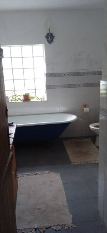 Interior view of a rustic bathroom with a bathtub and window in Santa Comba Dao, Portugal.