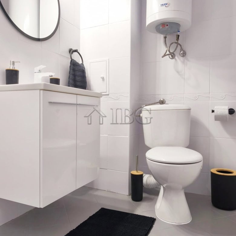 Cozy bathroom with modern fixtures, water heater, and black accessories in a stylish apartment.