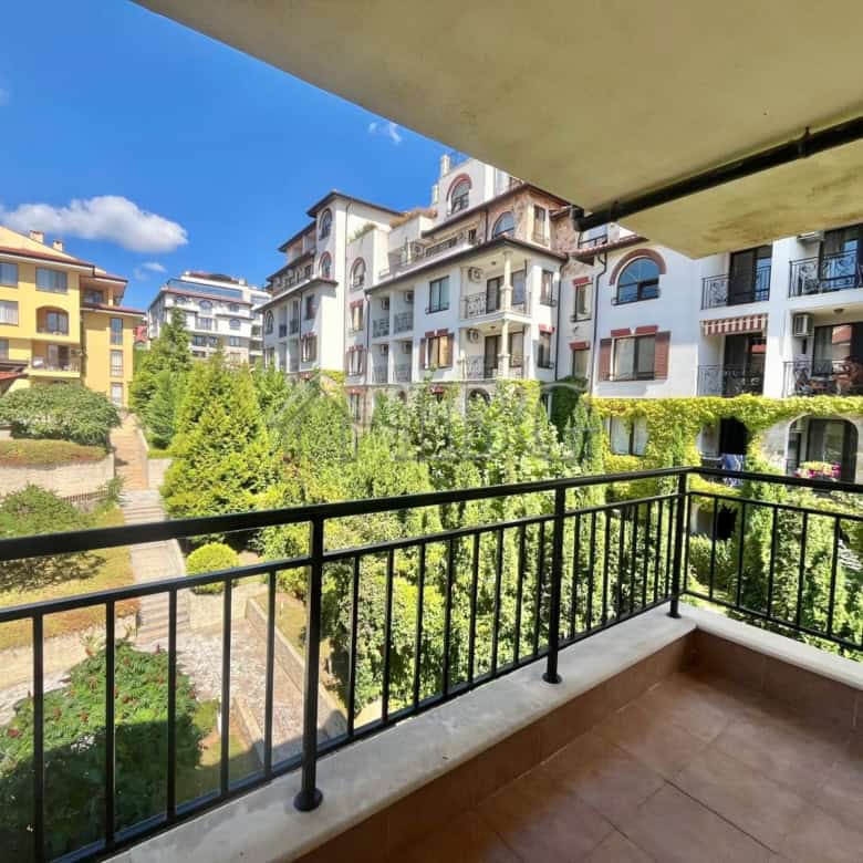 Bright balcony view of Sveti Vlas with lush greenery and modern buildings.