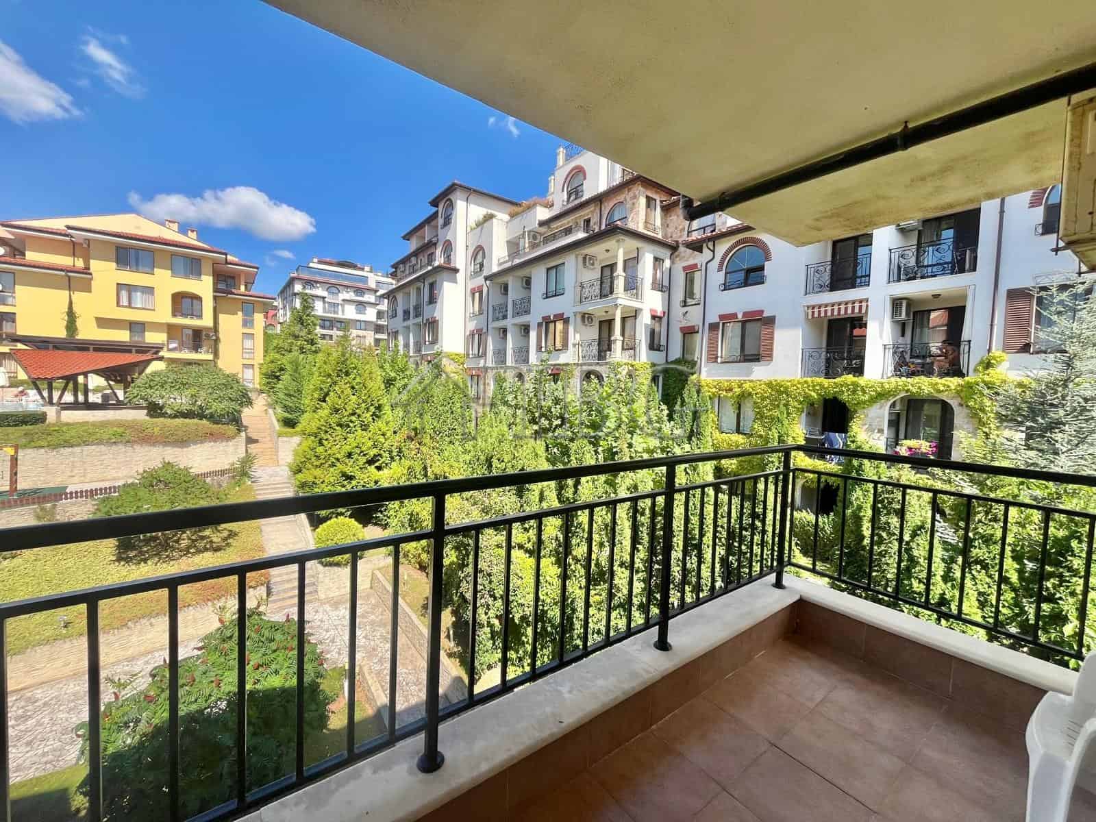 Bright balcony view of Sveti Vlas with lush greenery and modern buildings.