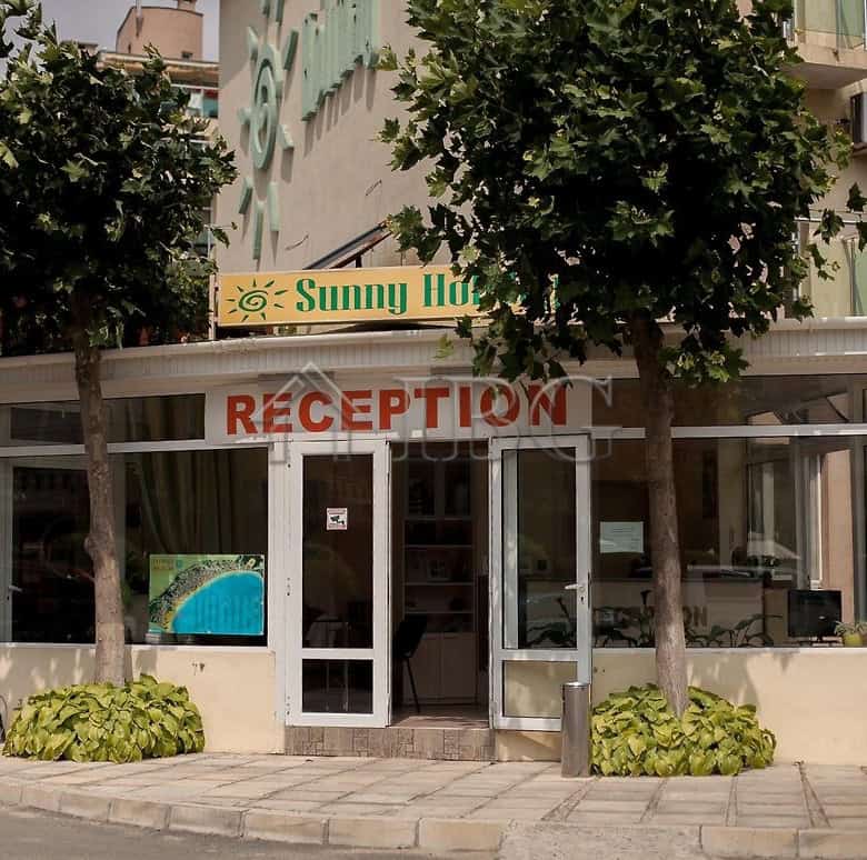 Reception area of Sunny Holiday hotel in Sunny Beach with glass doors and welcoming signage.