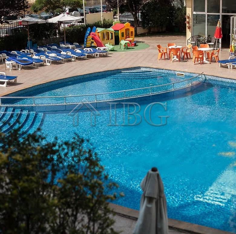 Outdoor swimming pool at Sunny Beach with sun loungers and children’s play area.