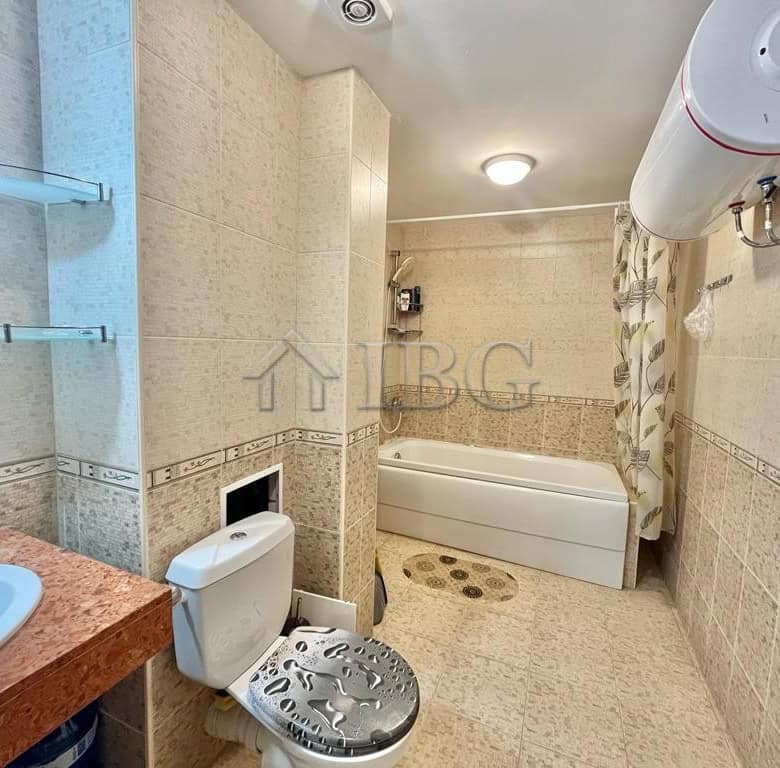 Spacious bathroom featuring a bathtub, water heater, and modern fixtures in a sunny beachfront prope.