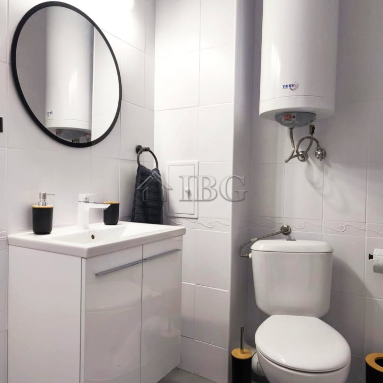 Bright studio bathroom with modern fixtures and sea view balcony.