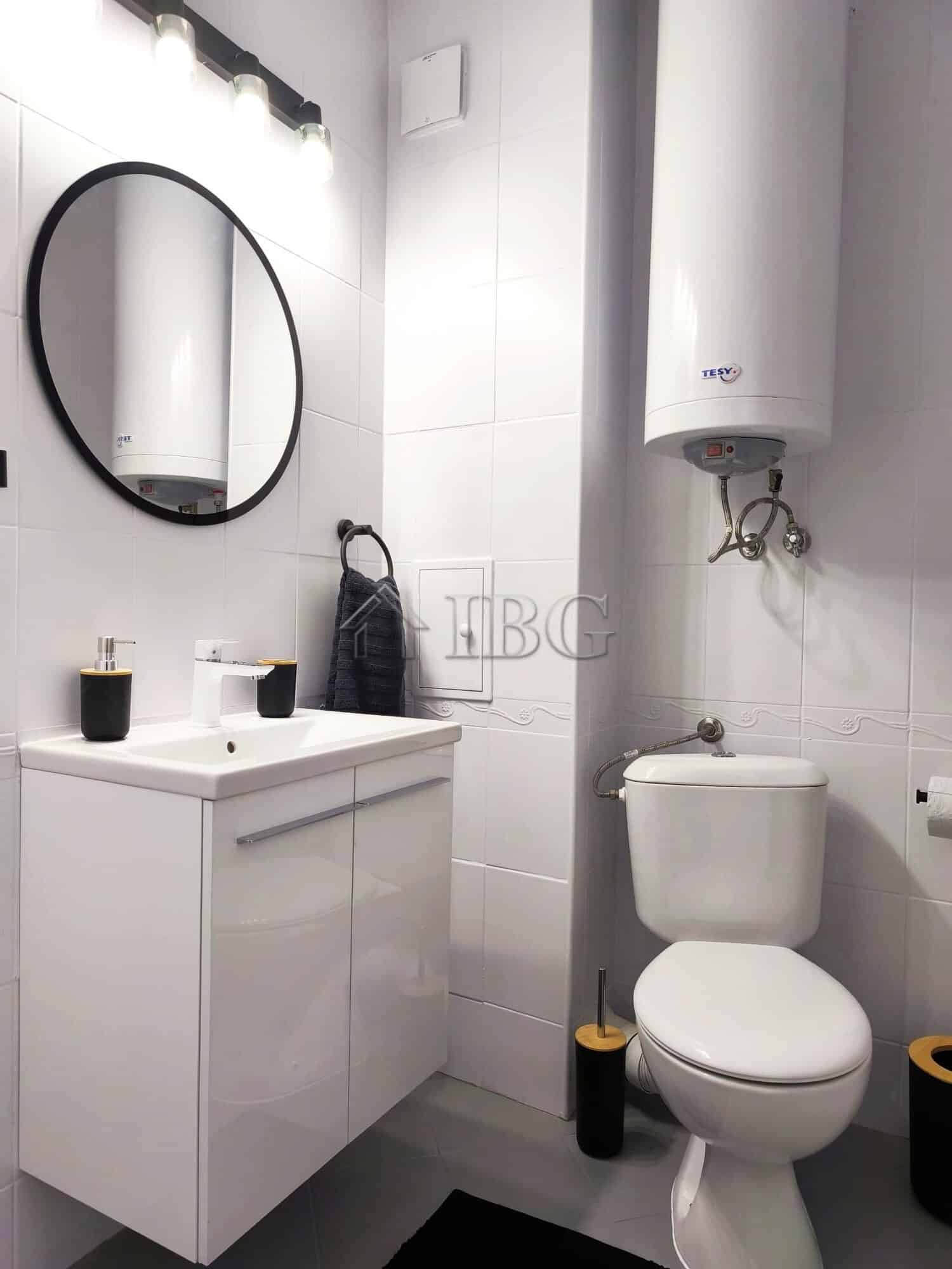 Bright studio bathroom with modern fixtures and sea view balcony.
