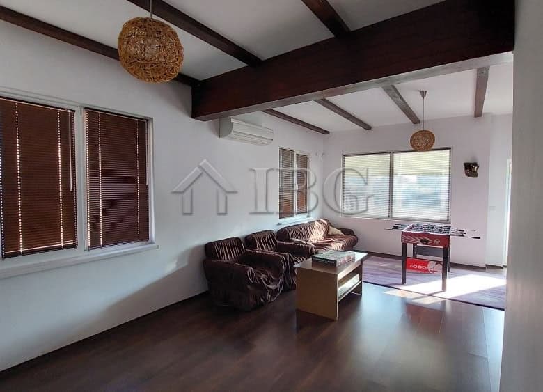 Bright living room with large windows and wooden ceiling beams in a family house in Burgas.