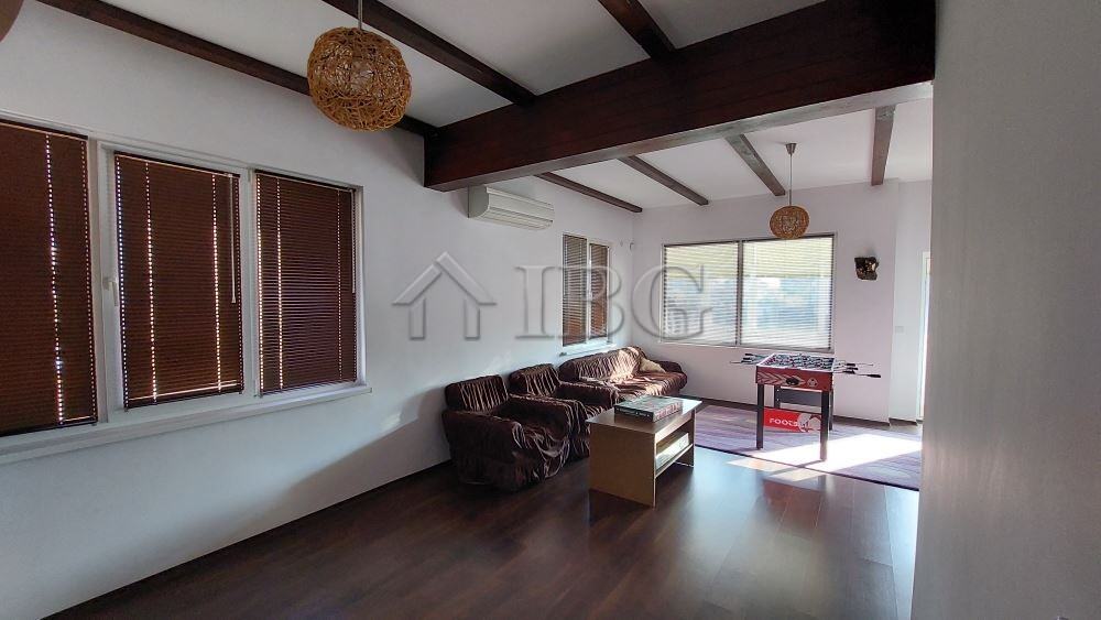 Bright living room with large windows and wooden ceiling beams in a family house in Burgas.