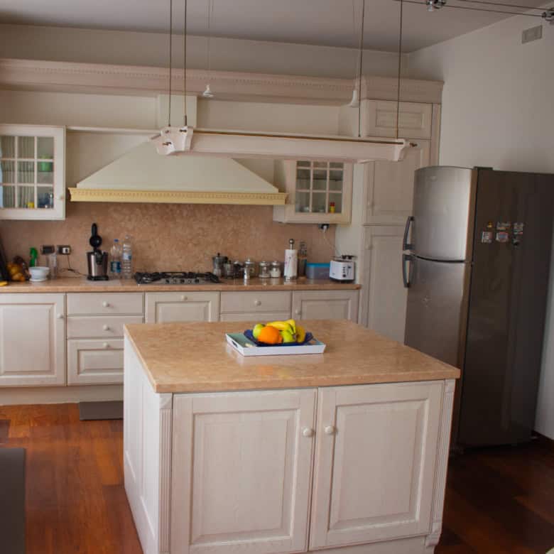 Spacious kitchen featuring white cabinets, a central island, and modern appliances.