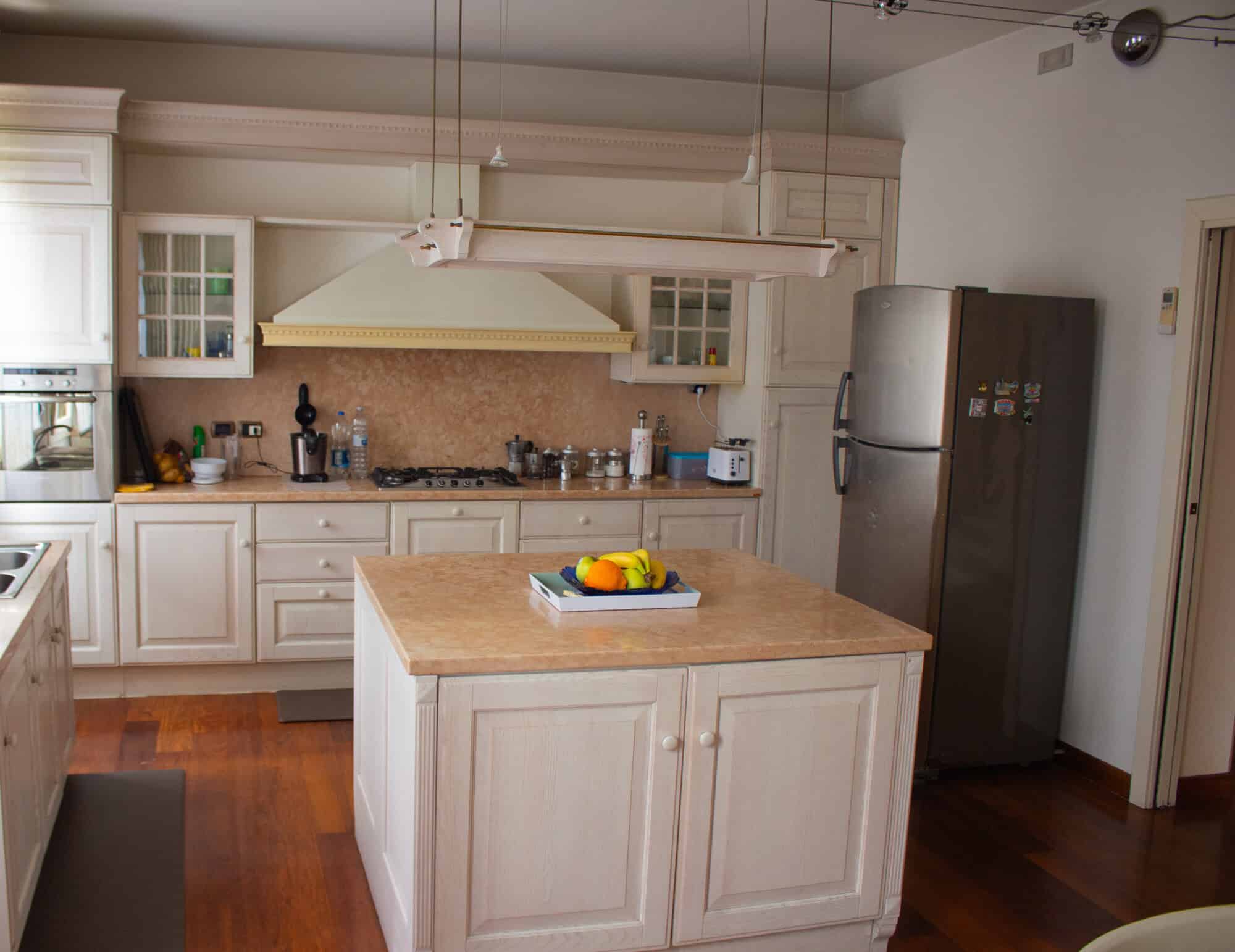 Spacious kitchen featuring white cabinets, a central island, and modern appliances.