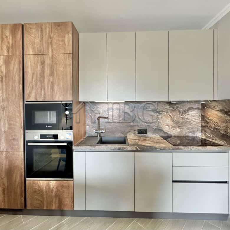 Modern kitchen with wooden and white cabinetry, marble backsplash, and built-in appliances in Valenc.
