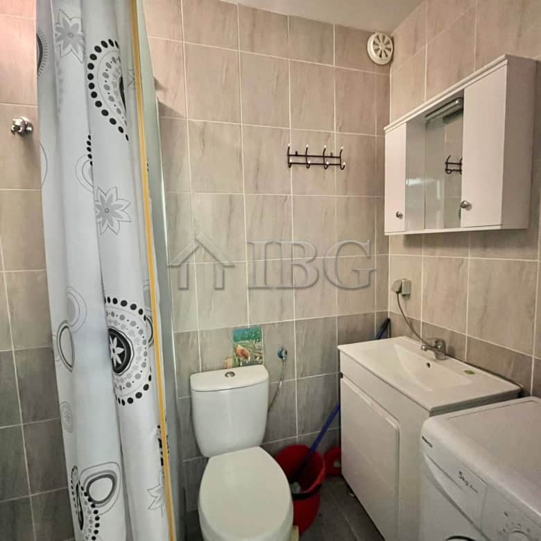 Bright bathroom with toilet, sink, and washing machine in Sveti Vlas.
