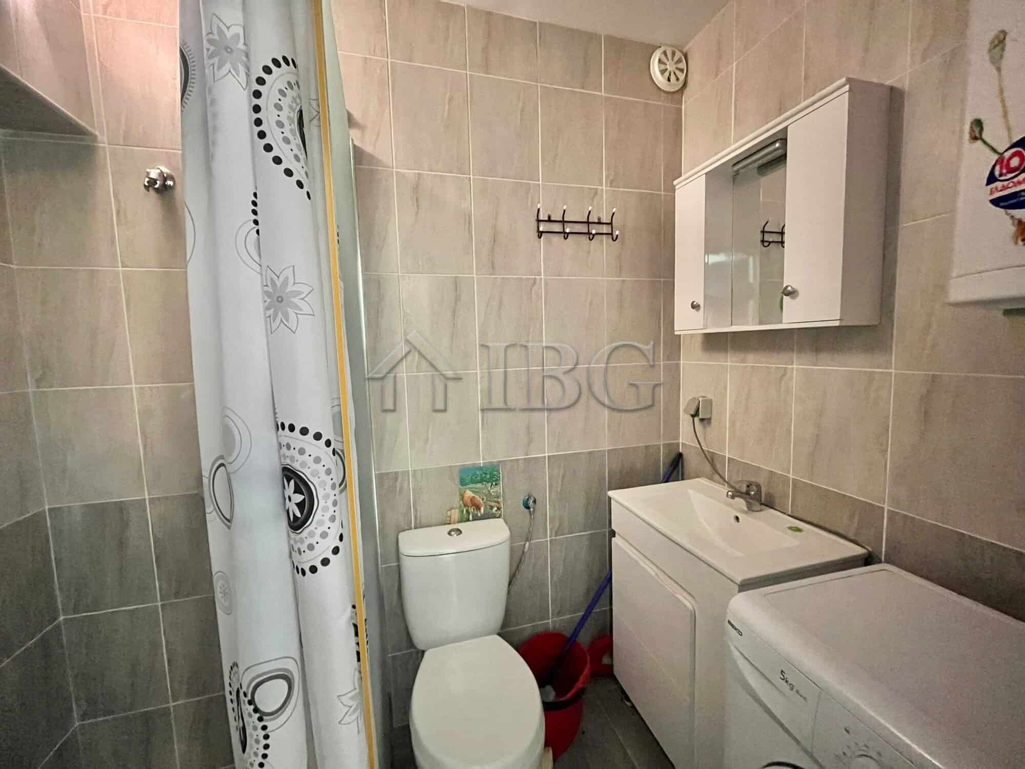 Bright bathroom with toilet, sink, and washing machine in Sveti Vlas.